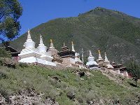 A row of stupas along a road.